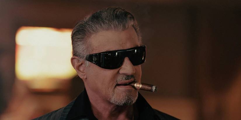 Sylvester Stallone in sunglasses smoking a cigar in Tulsa King
