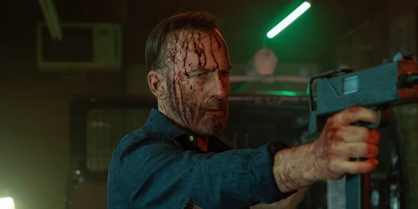 Bob Odenkirk in Nobody 2 with blood on his face holding a gun