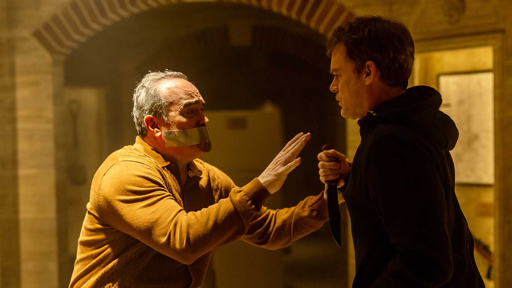 Angel with tape over his mouth pleading with Dexter in Dexter: Resurrection.