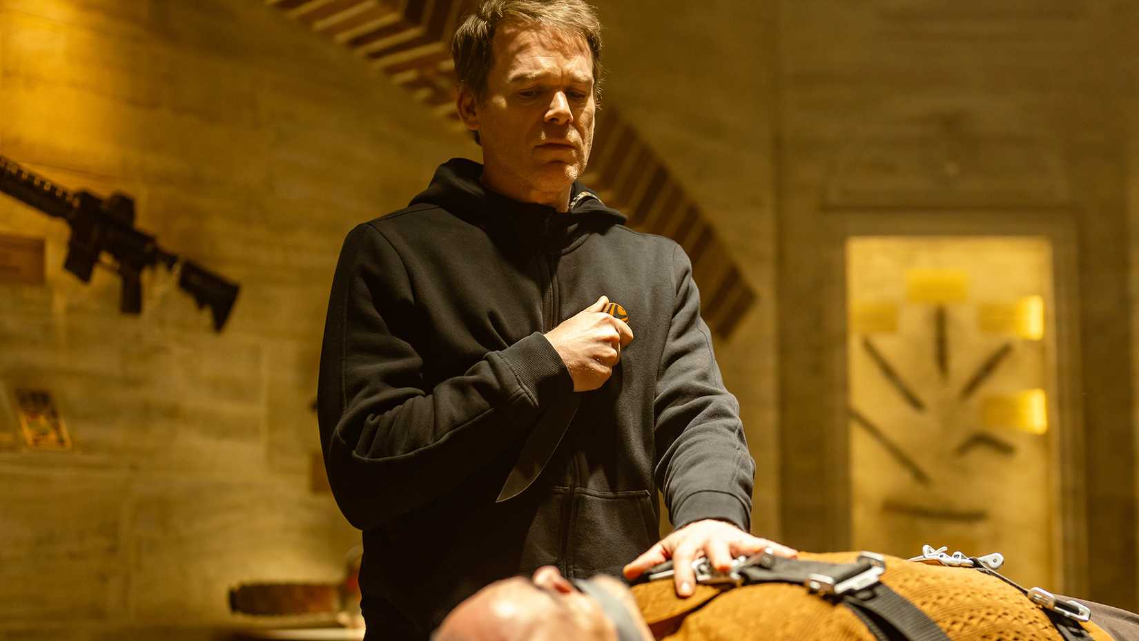 Dexter standing over Angel strapped to a table while holding a knife in Dexter: Resurrection.