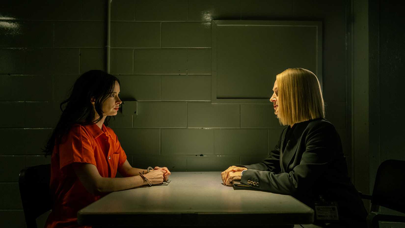 Mia and Charley sitting across from one another talking in jail in Dexter: Resurrection.