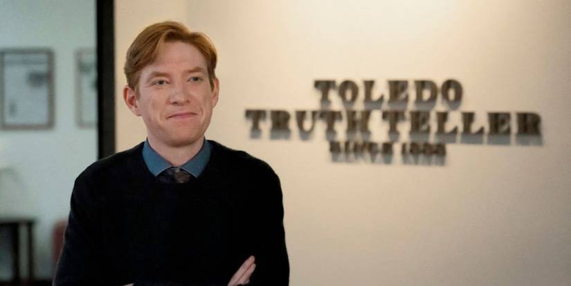 Domhnall Gleeson as Ned standing in front of the Toledo Truth Teller sign in The Paper