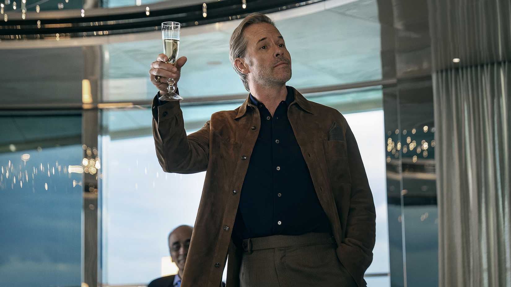 Guy Pearce raising a glass in The Woman in Cabin 10