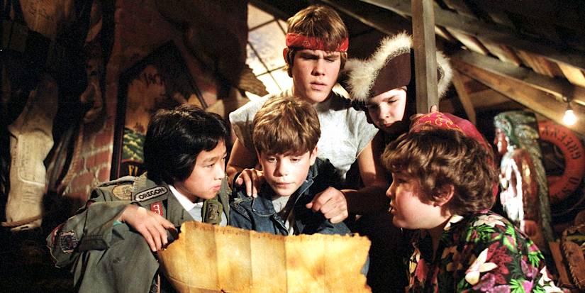 Data (Ke Huy Quan), Mikey (Sean Astin), Brand (Josh Brolin), Mouth (Corey Feldman), and Chunk (Jeff Cohen) gathered around a map in The Goonies
