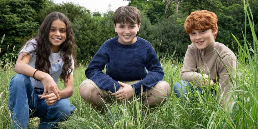 Hermione, Harry, and Ron kneel in the grass for HBO's Harry Potter