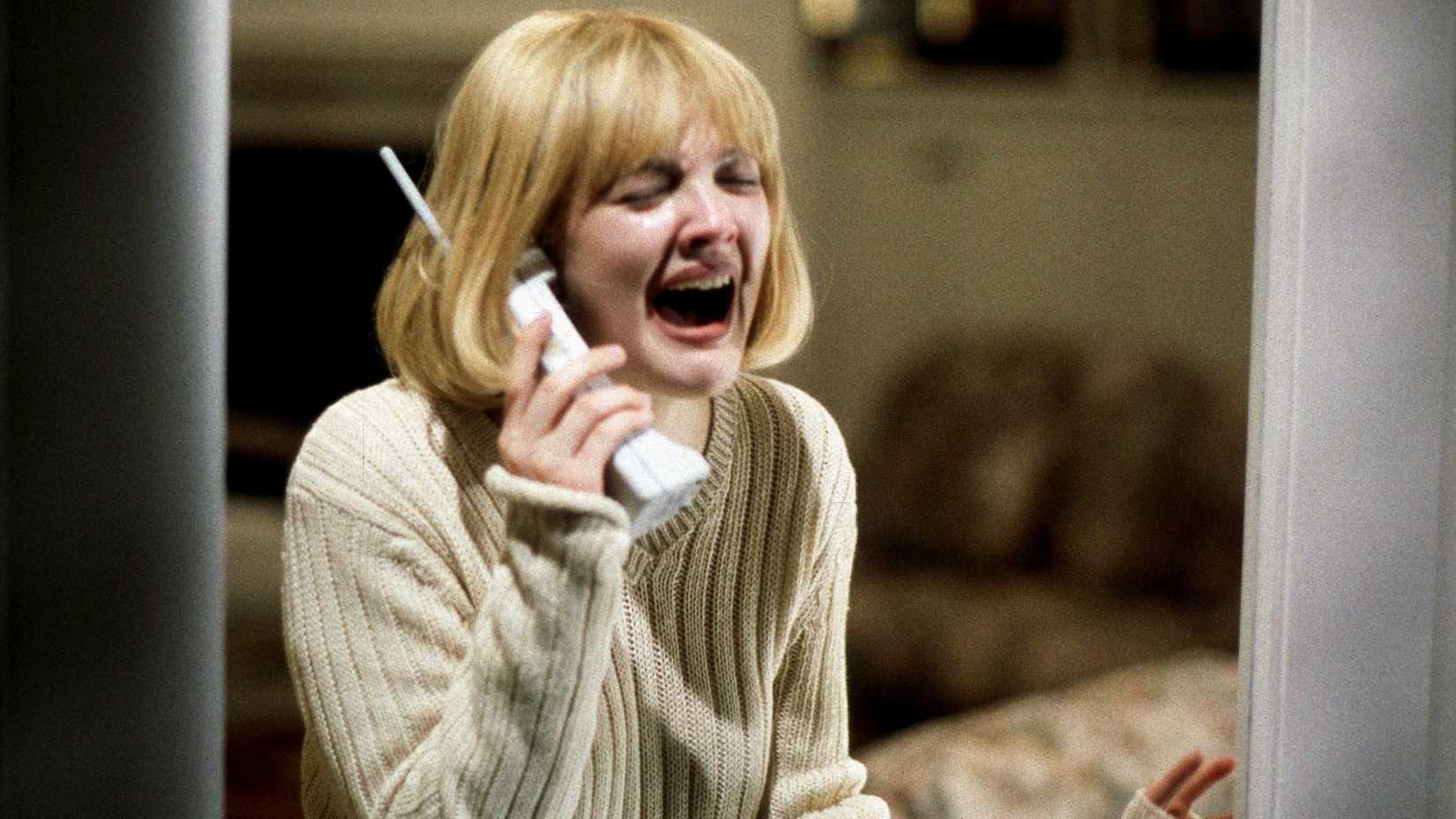 Drew Barrymore in Scream screaming while holding a telephone