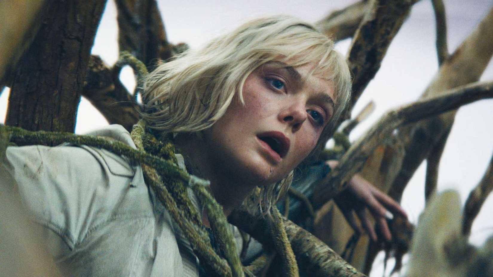 Elle Fanning hangs from a tree in Predator Badlands