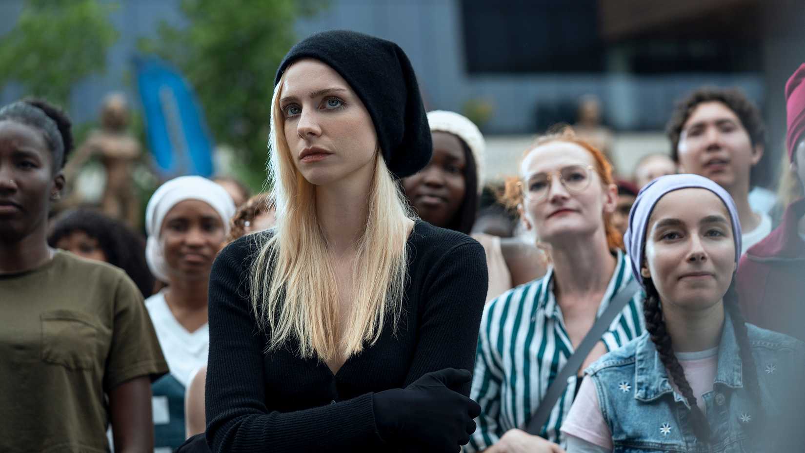 Cate standing in a crowd looking pensive in Gen V.