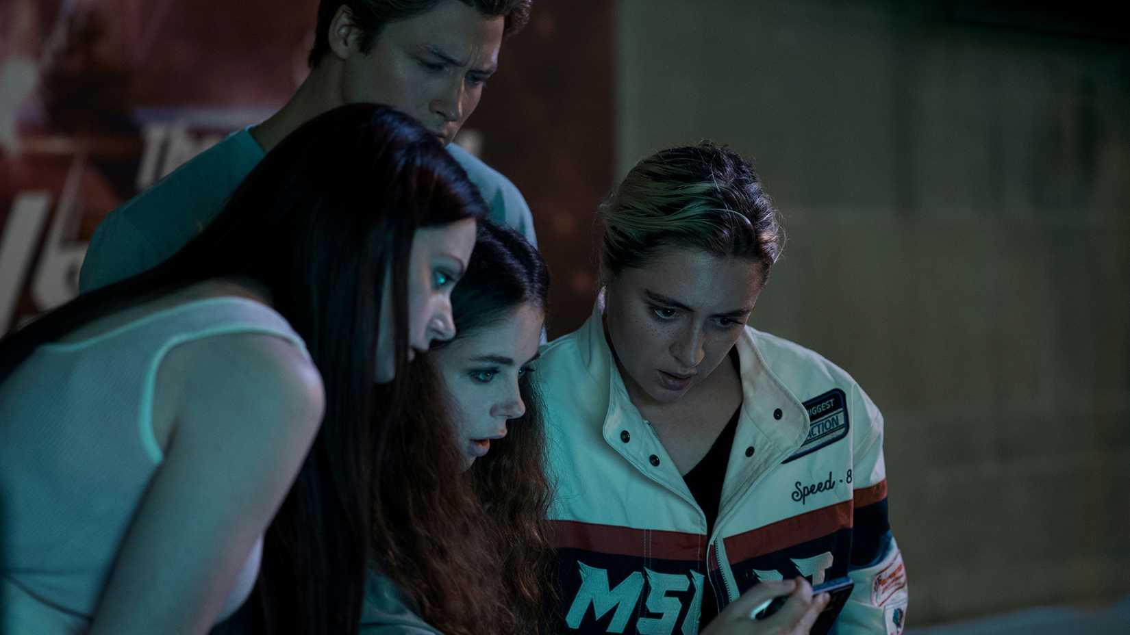 Emma with her new friends looking at a phone in Gen V.