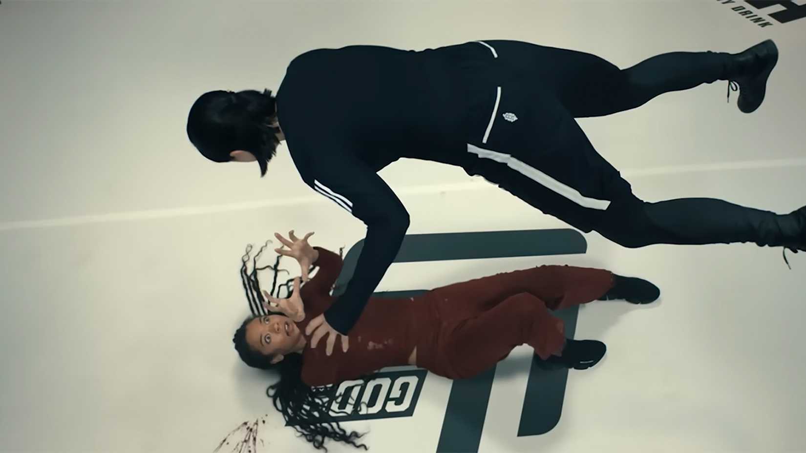 Marie lying on the ground in a ring with Jordan levitating above her in Gen V.