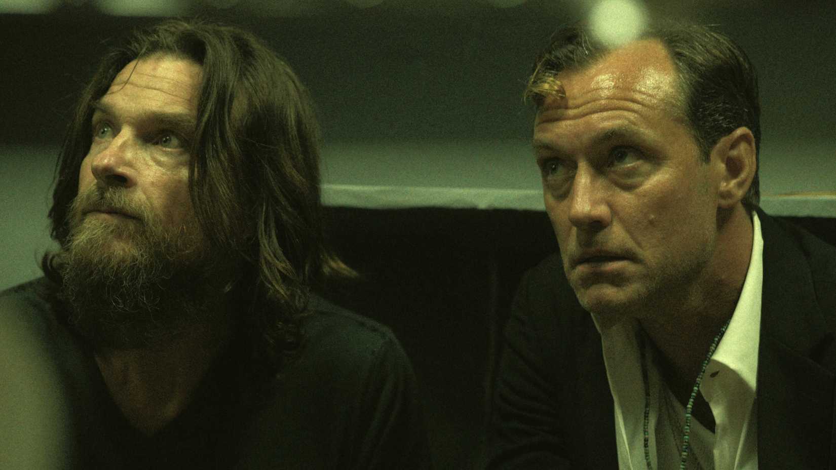 Jude Law and Jason Bateman in Black Rabbit looking up at someone with a worried look on their face
