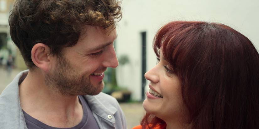 Laurie Davidson and Olivia Cooke in The Girlfriend looking at each other and smiling