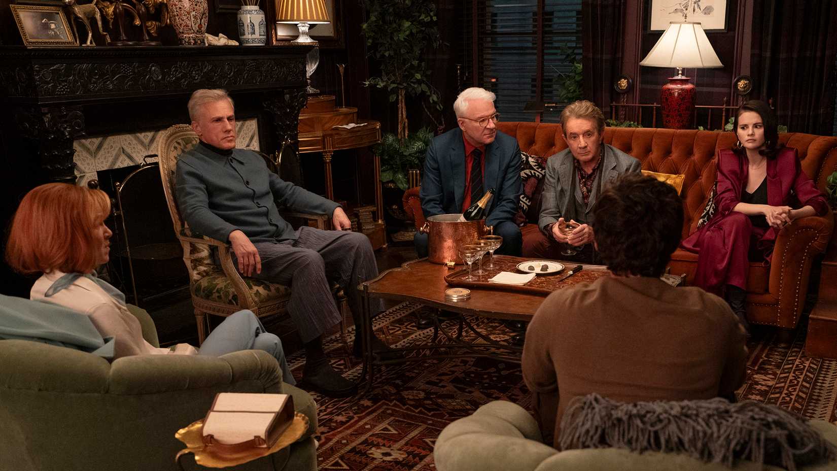 Charles, Oliver, and Mabel sitting with three billionaires in Only Murders in the Building.