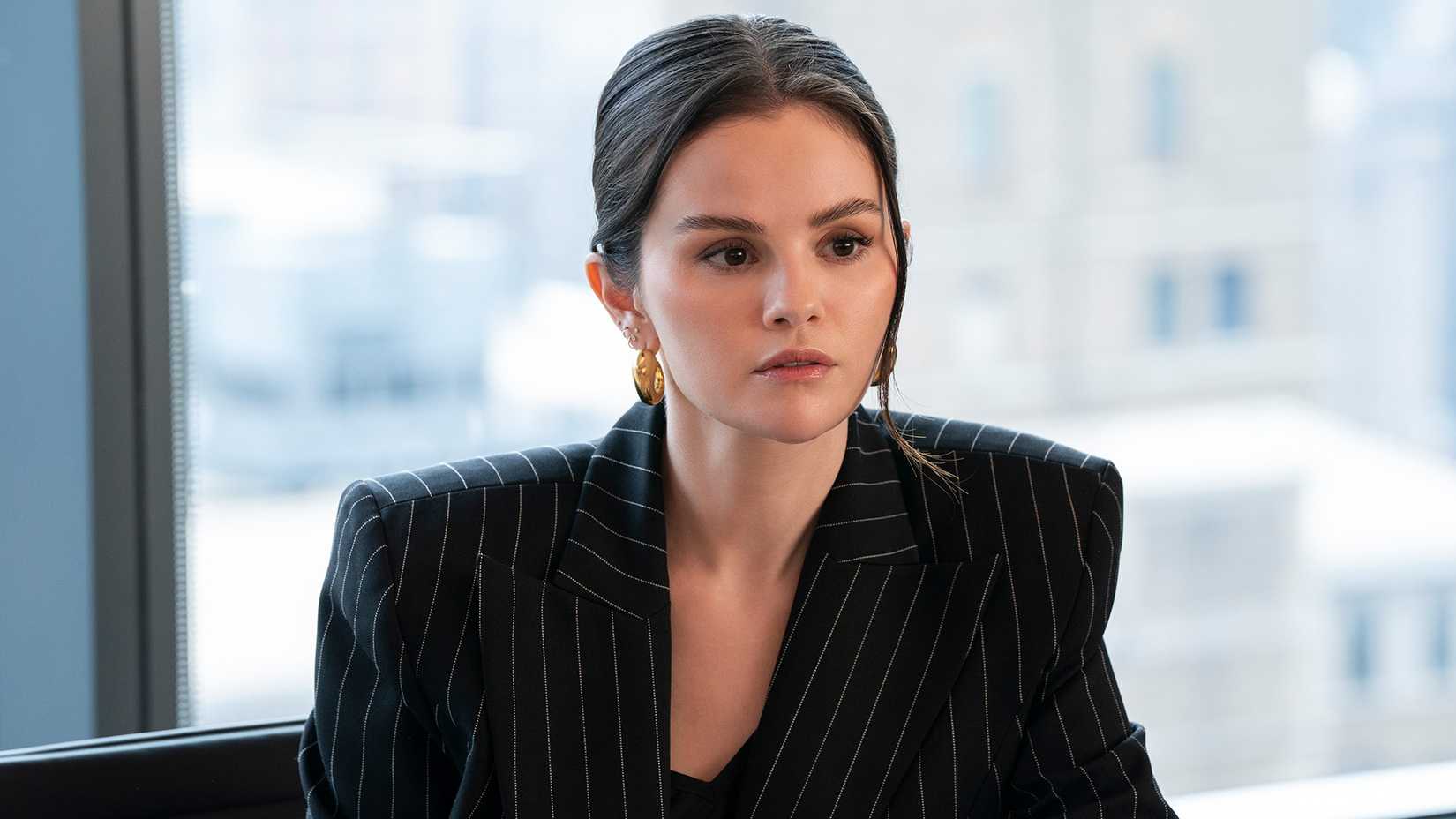 Mabel staring into space in an office in Only Murders in the Building.