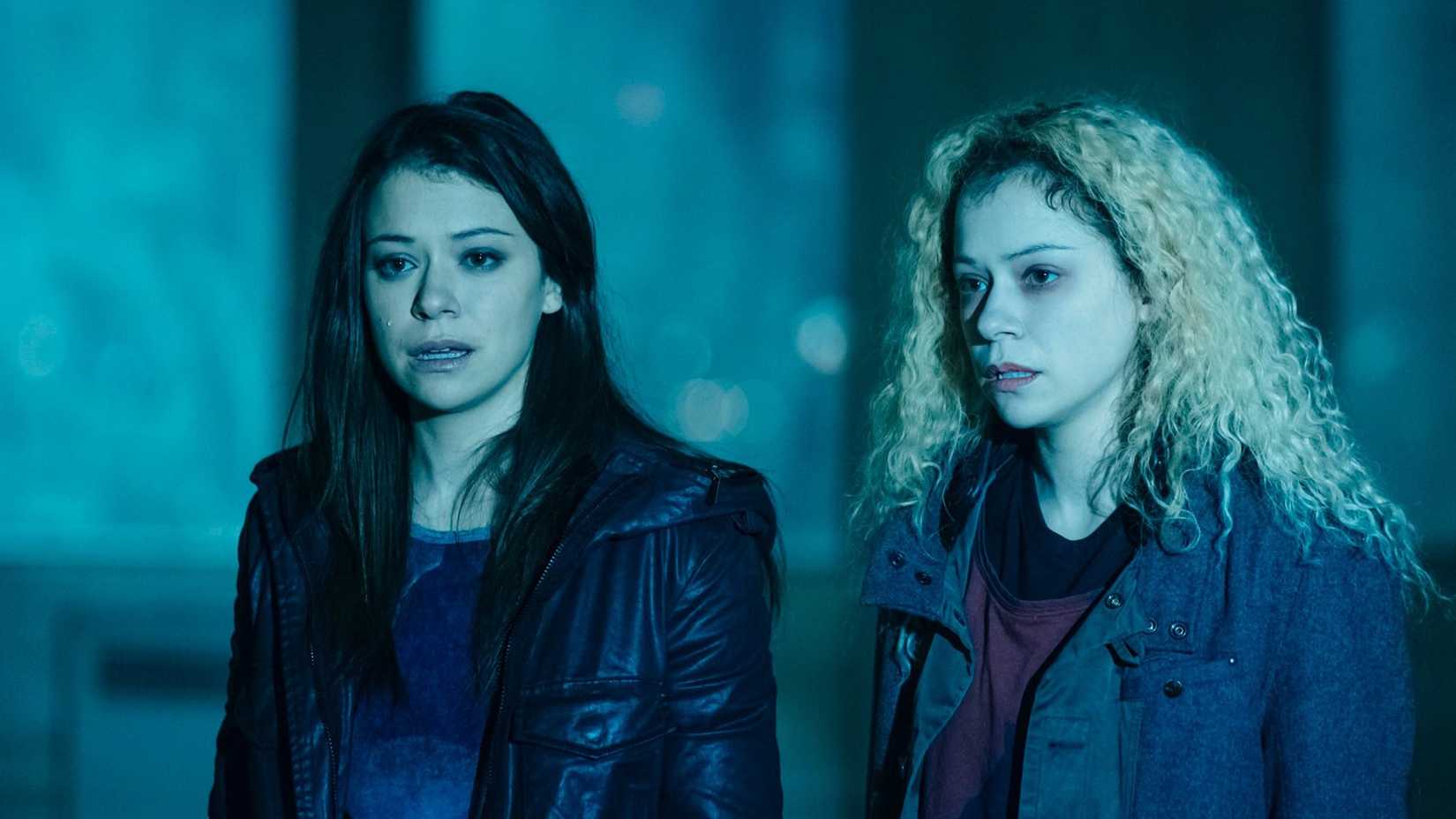 Татьяна Маслани в роли Сары и Хелены в темноте, выглядящих ошеломленными в фильме «Черная сирота».