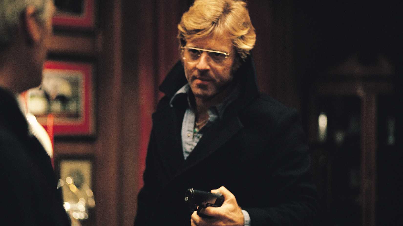 Robert Redford in Three Days of the Condor holding a pistol and looking at someone off-screen