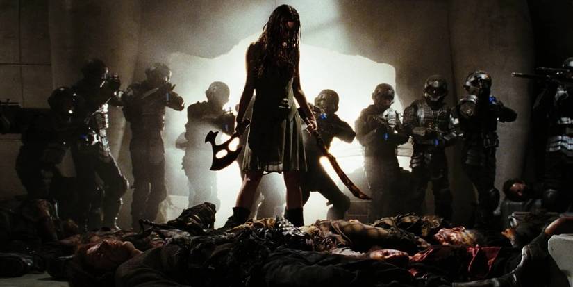 River Tam (Summer Glau) stands above a pile of bodies while soldiers crowd in behind her in Serenity (2005)