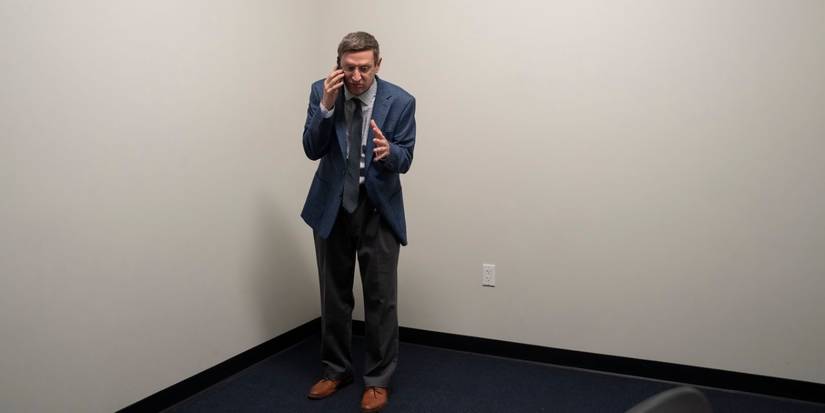 Tim Robinson standing in a corner on the phone in the HBO comedy series The Chair Company