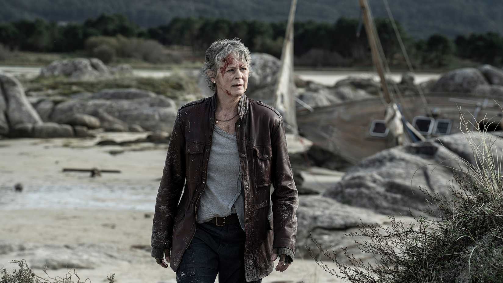 Carol standing on the shore looking at something by the water in The Walking Dead: Daryl Dixon.