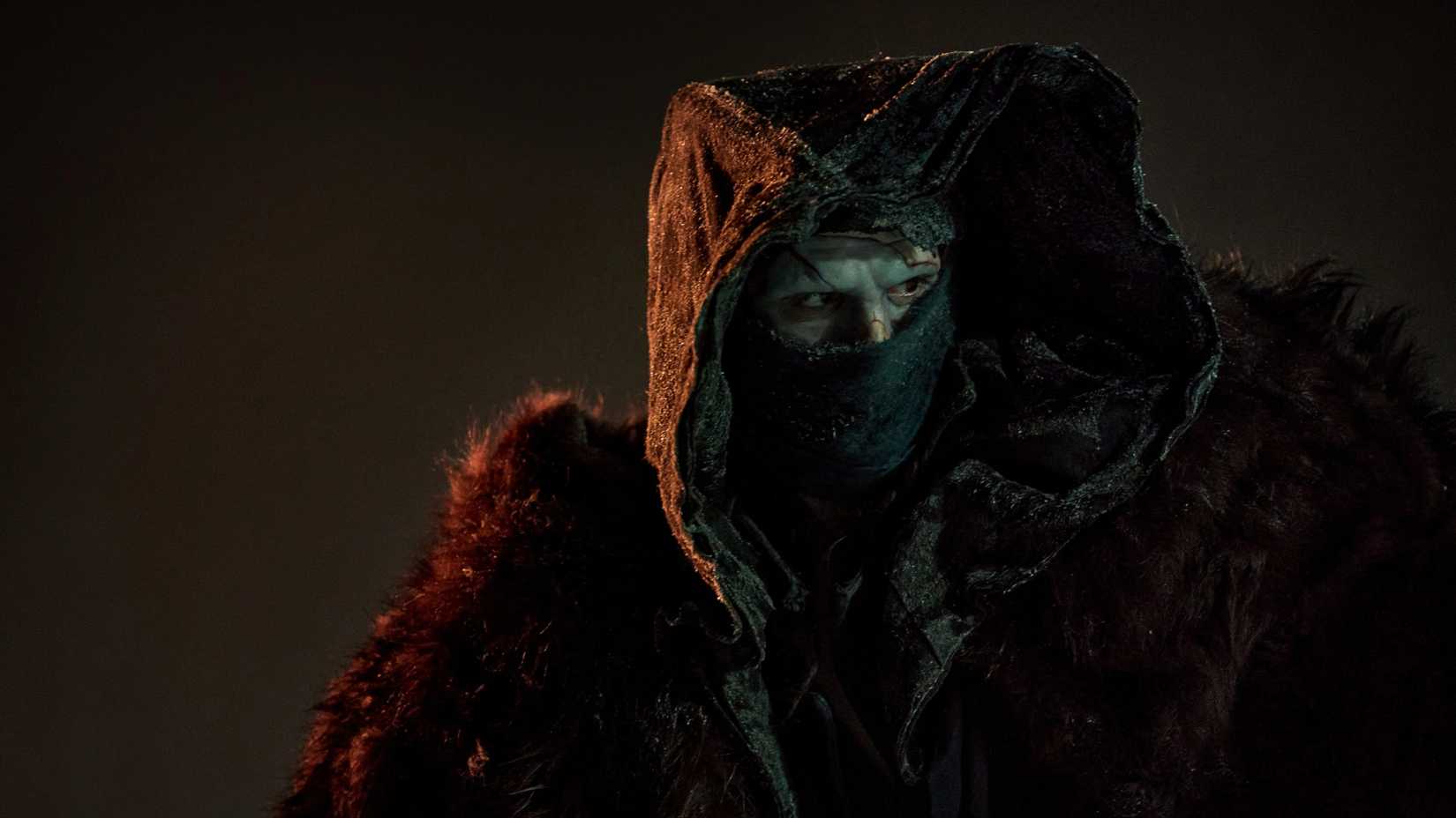 Jacob Elordi in Frankenstein wearing a hood and mask looking off-screen