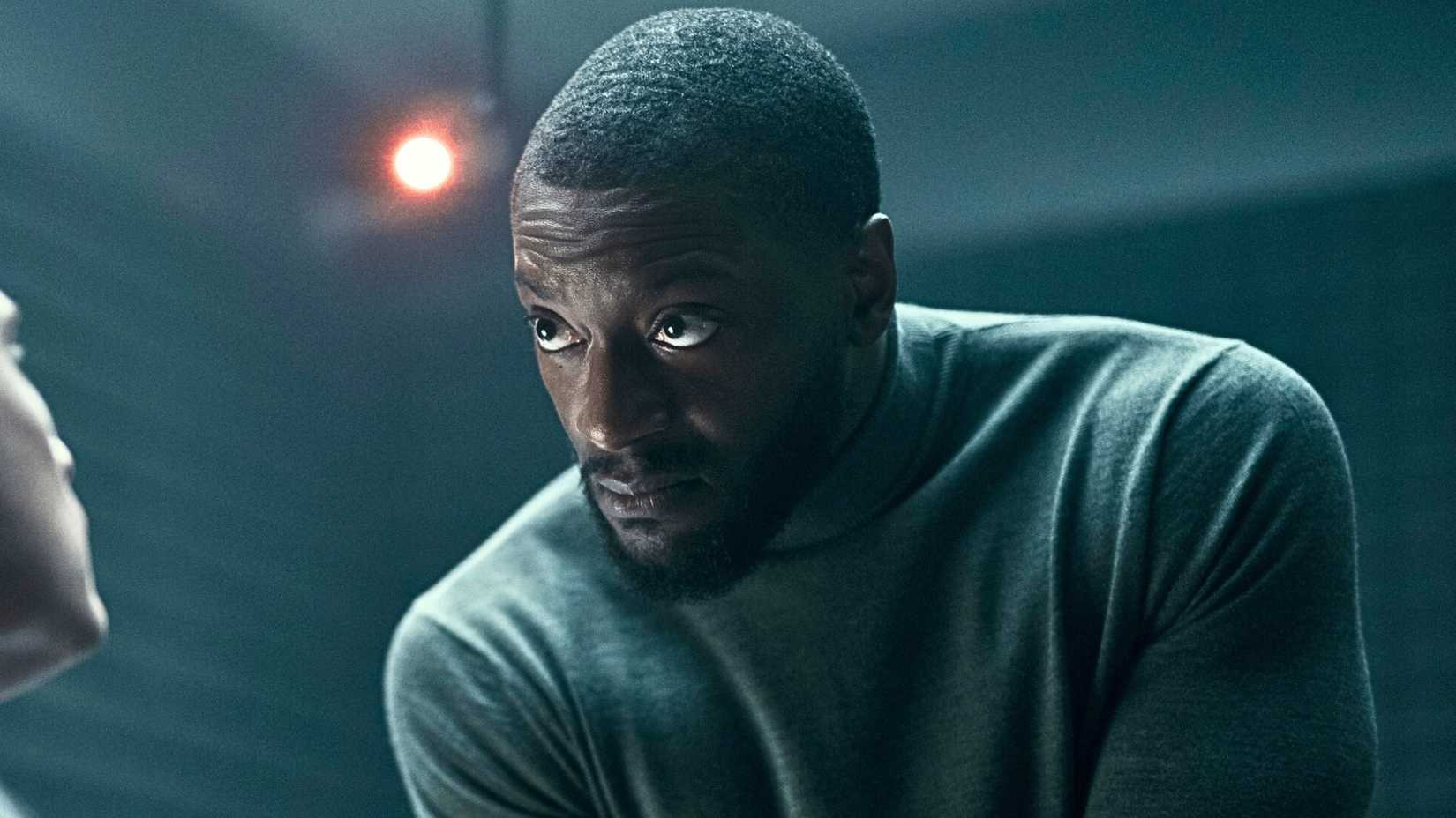 Aldis Hodge in Cross looking intently at someone