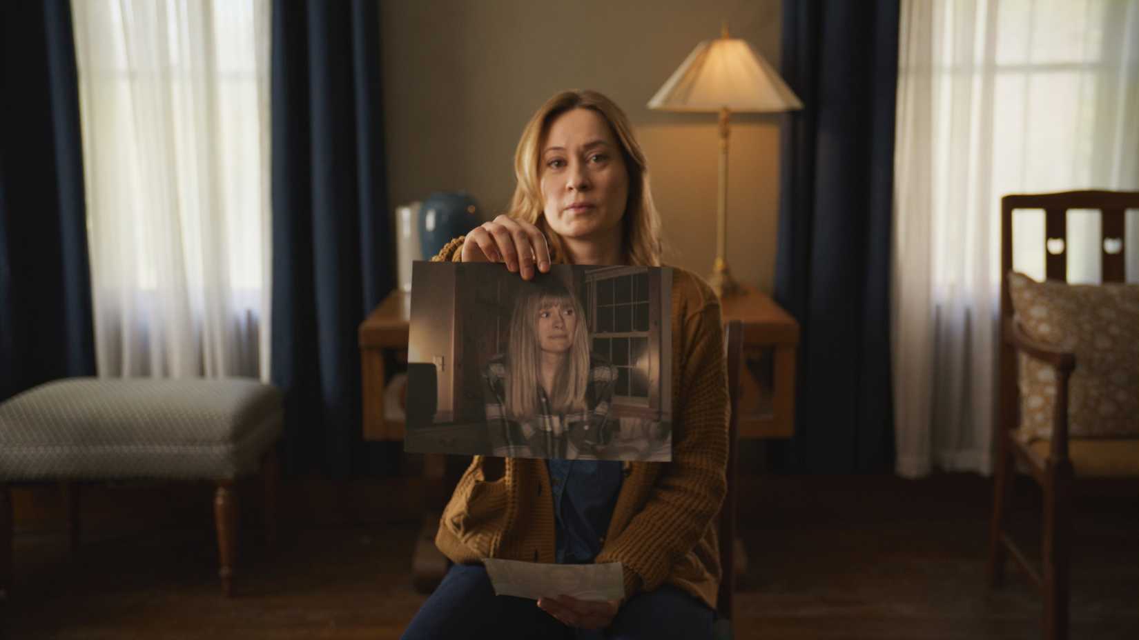 Camille Sullivan holds up a photo of her late sister in Shelby Oaks