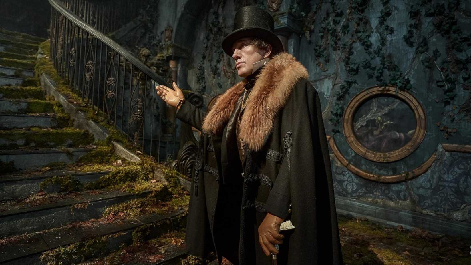Christoph Waltz as Henrich Harlander in Frankenstein motioning someone to walk up the stairs