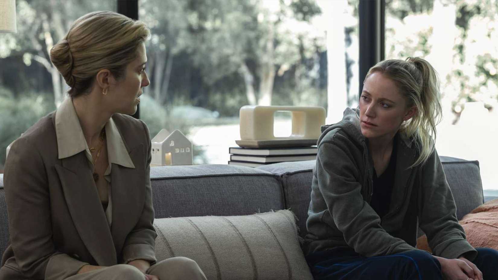 Caitlyn and Polly sit on a sofa in The Hand That Rocks the Cradle