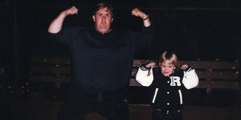 John Candy flexing next to a child in an image from the documentary John Candy: I Like Me
