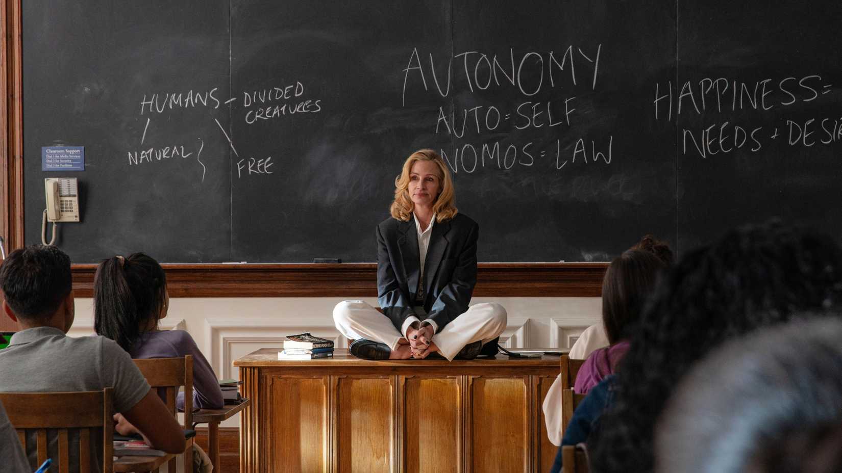 Julia Roberts in After the Hunt sitting on a desk in a classroom