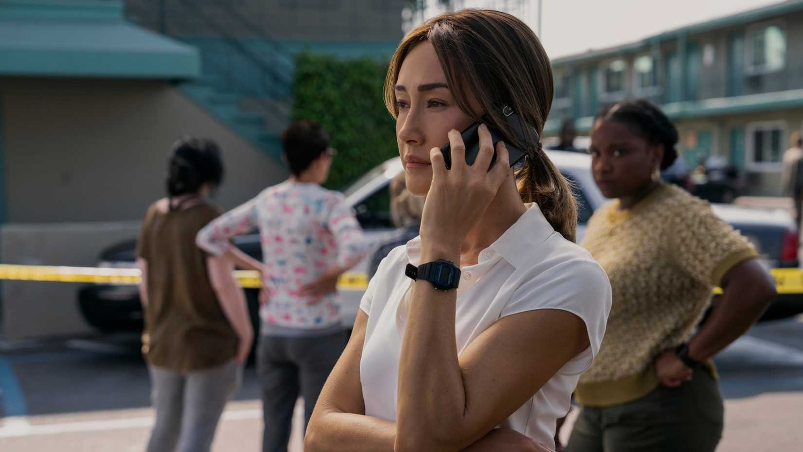 Maggie Q as Detective Renée Ballard on the phone.