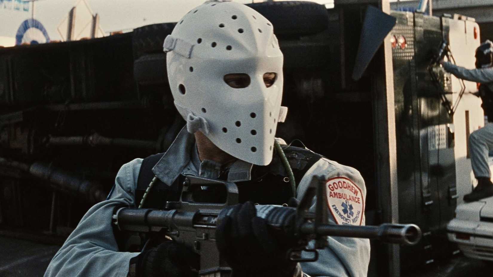 Masked man with rifle in Heat