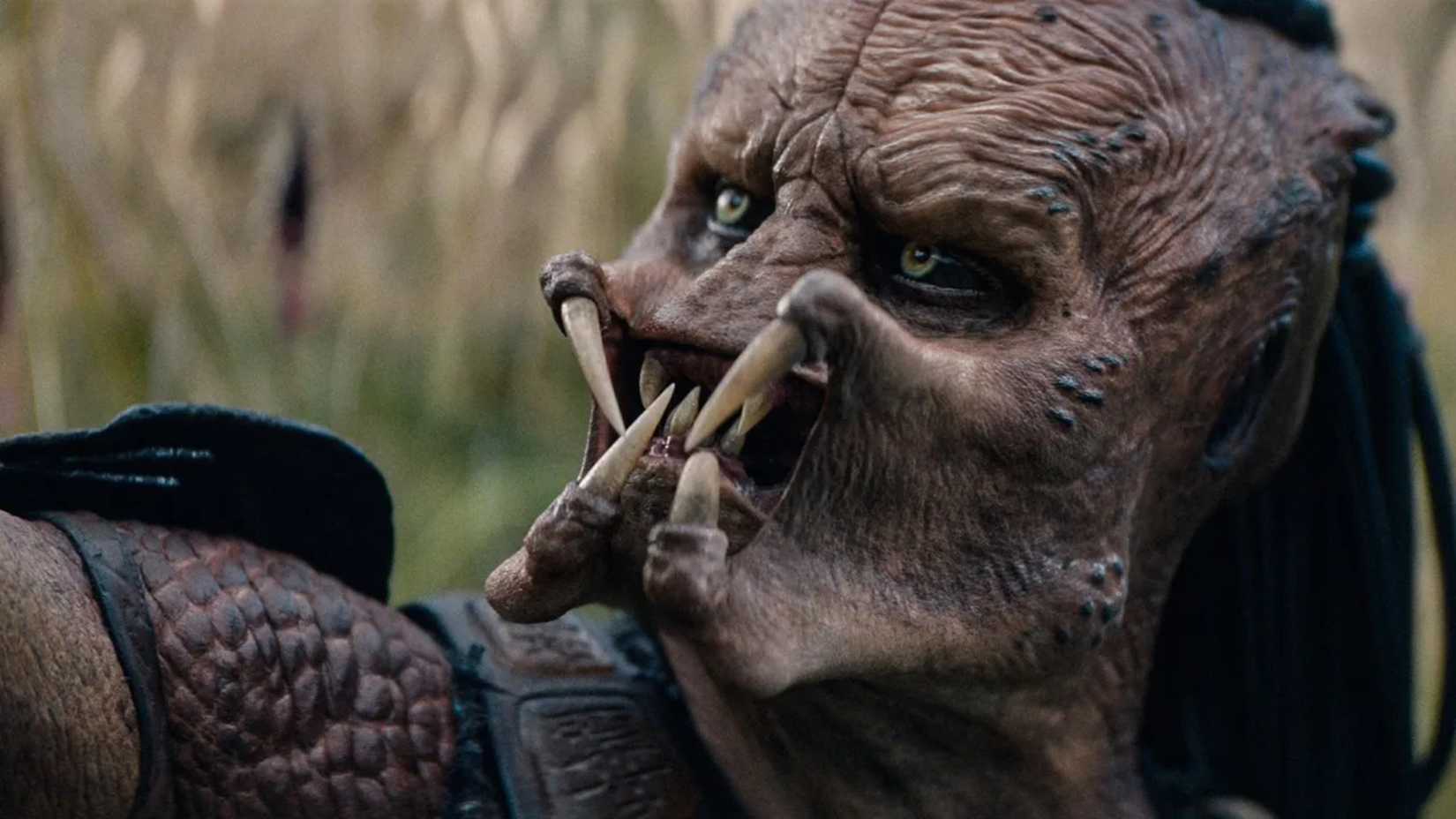 The Predator in Predator Badlands holding something up off-screen