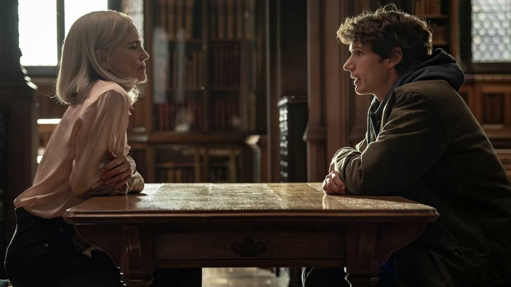 Helen and Guy sit across from each other in Talamasca: The Secret Order