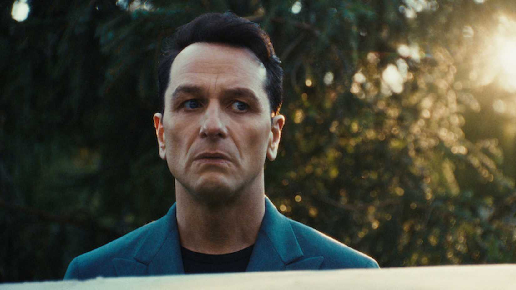 Nile Jarvis stands by a car in The Beast in Me