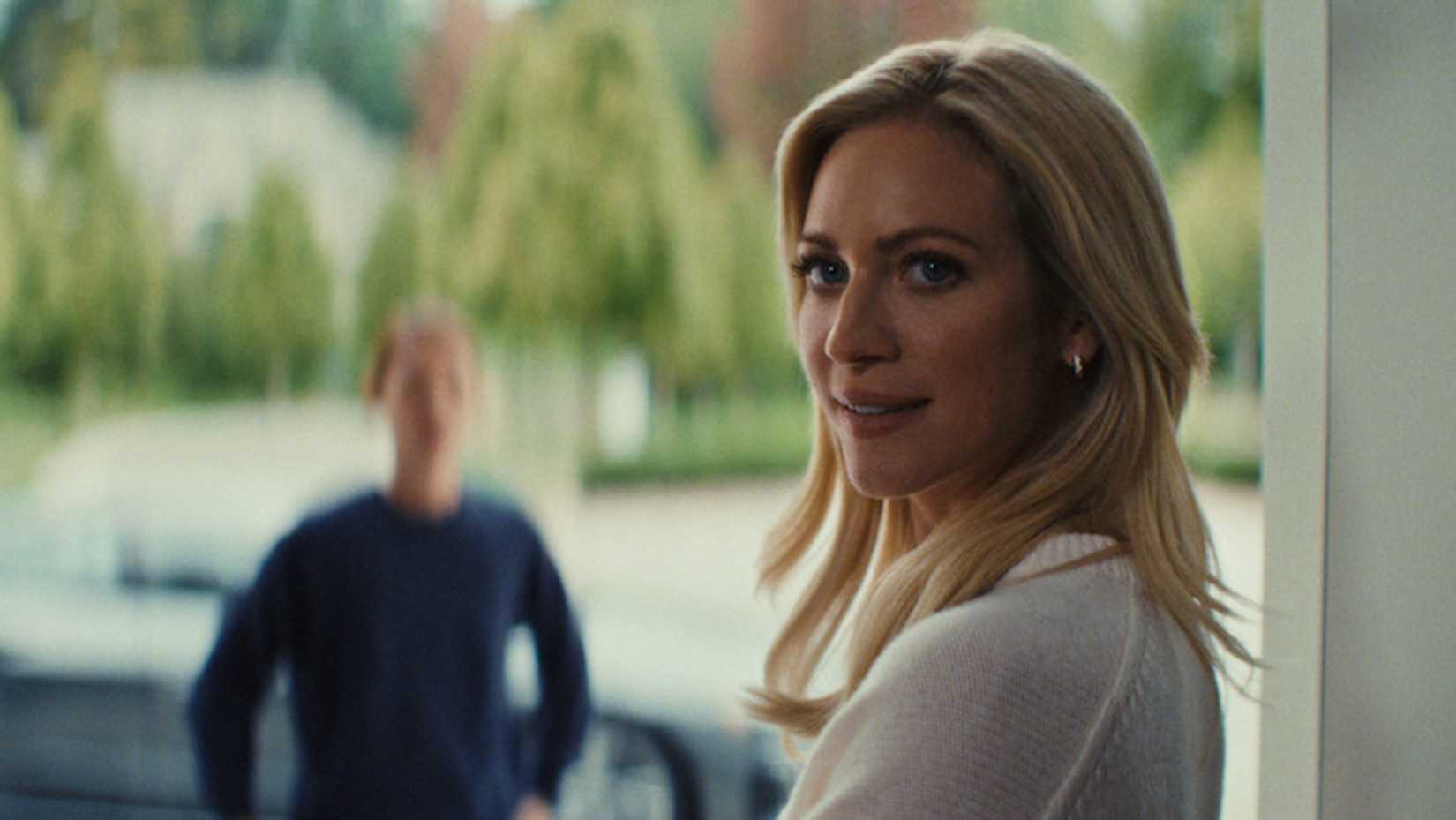 Nina smiles in a doorway in The Beast in Me