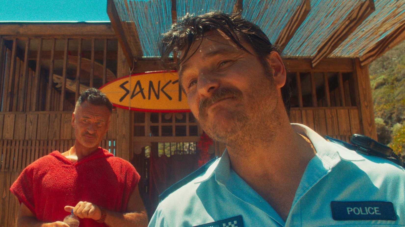 Julian McMahon as Scally with a police officer in The Surfer