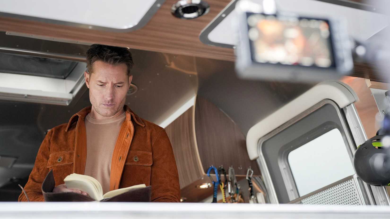 Colter flipping through a book in his trailer in Tracker