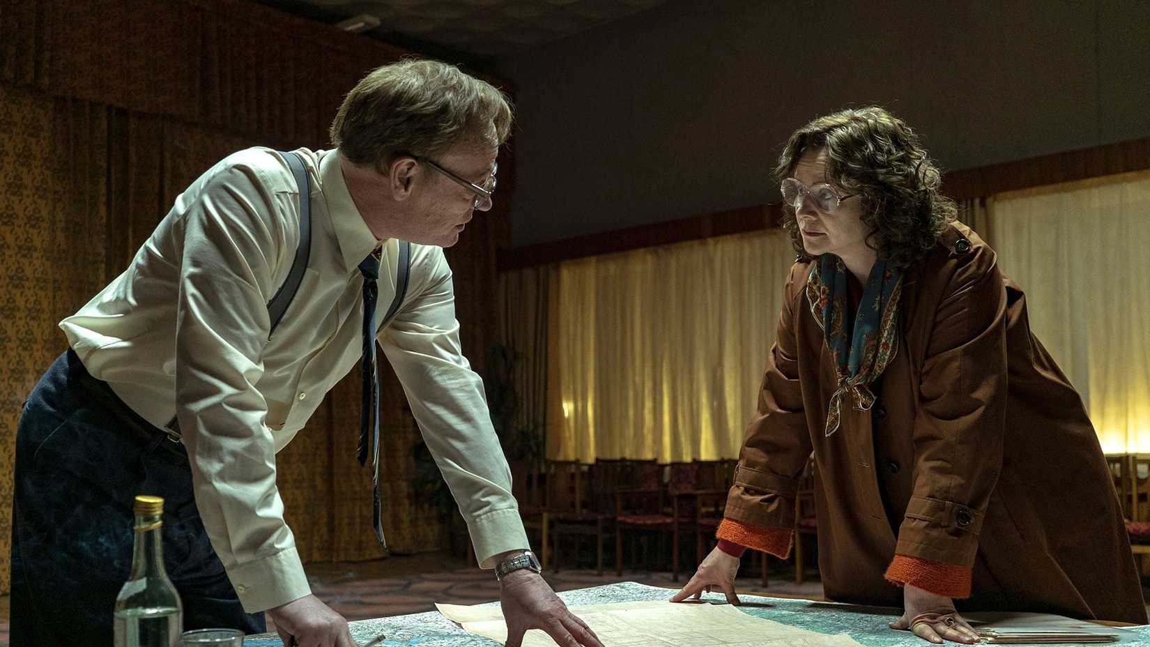 A man and woman looking over plans on a table in Chernobyl.