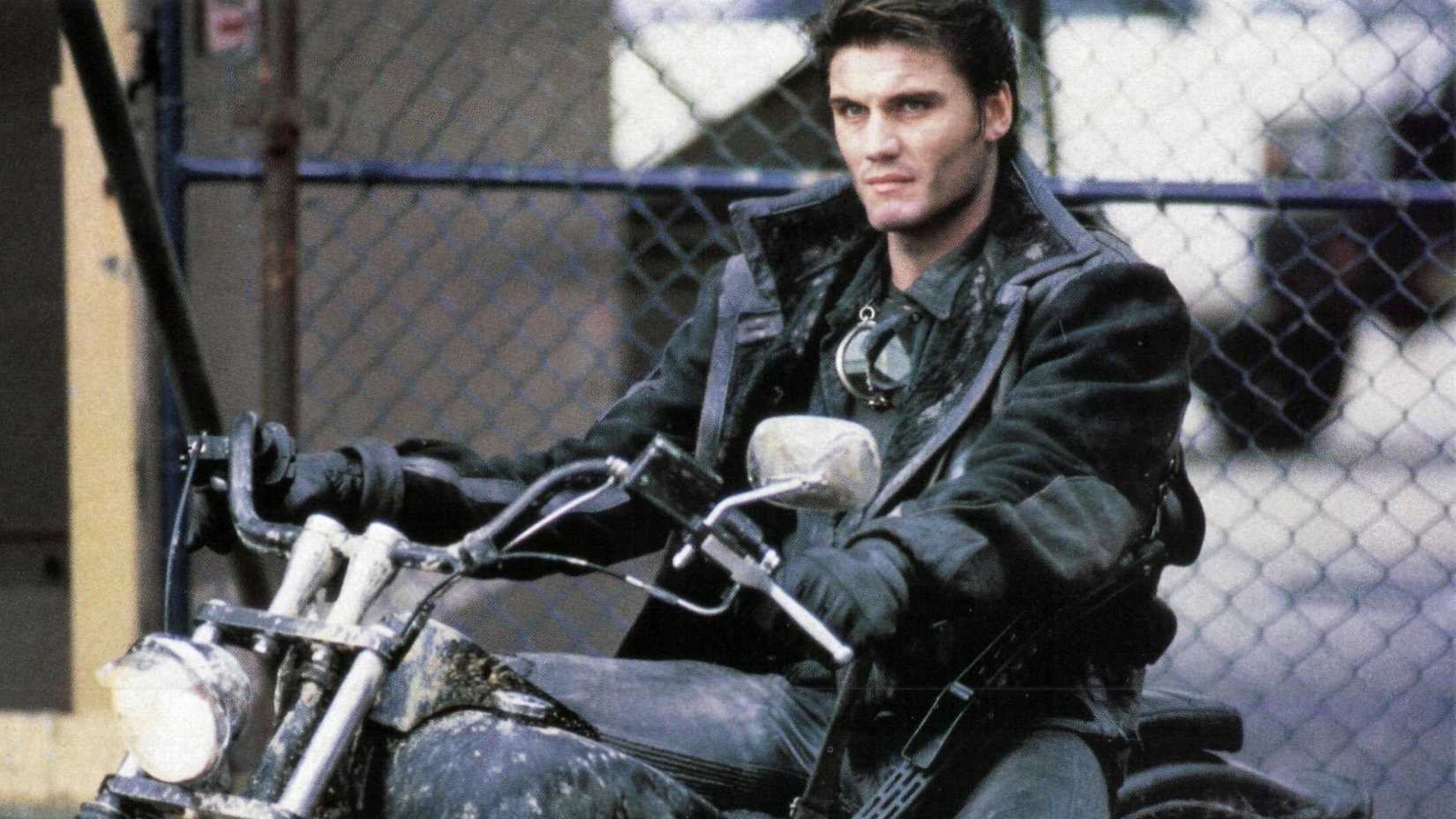Dolph Lundgren in The Punisher riding a motorcycle wearing an all black outfit