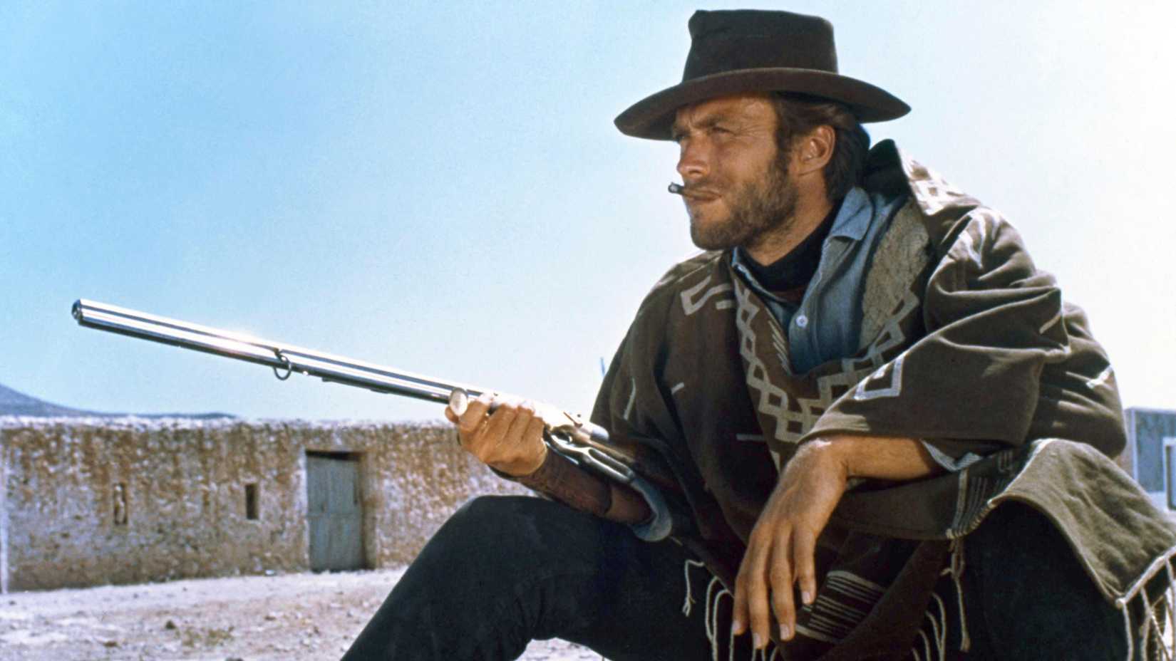 Clint Eastwood in For a Few Dollars More holding a rifle and smoking