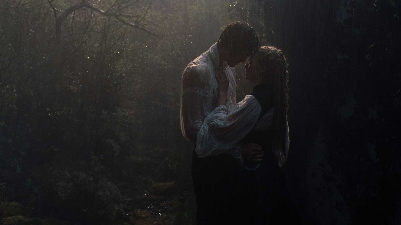 Cathy and Heathcliff embracing each other in the rain while in the woods in Wuthering Heights.