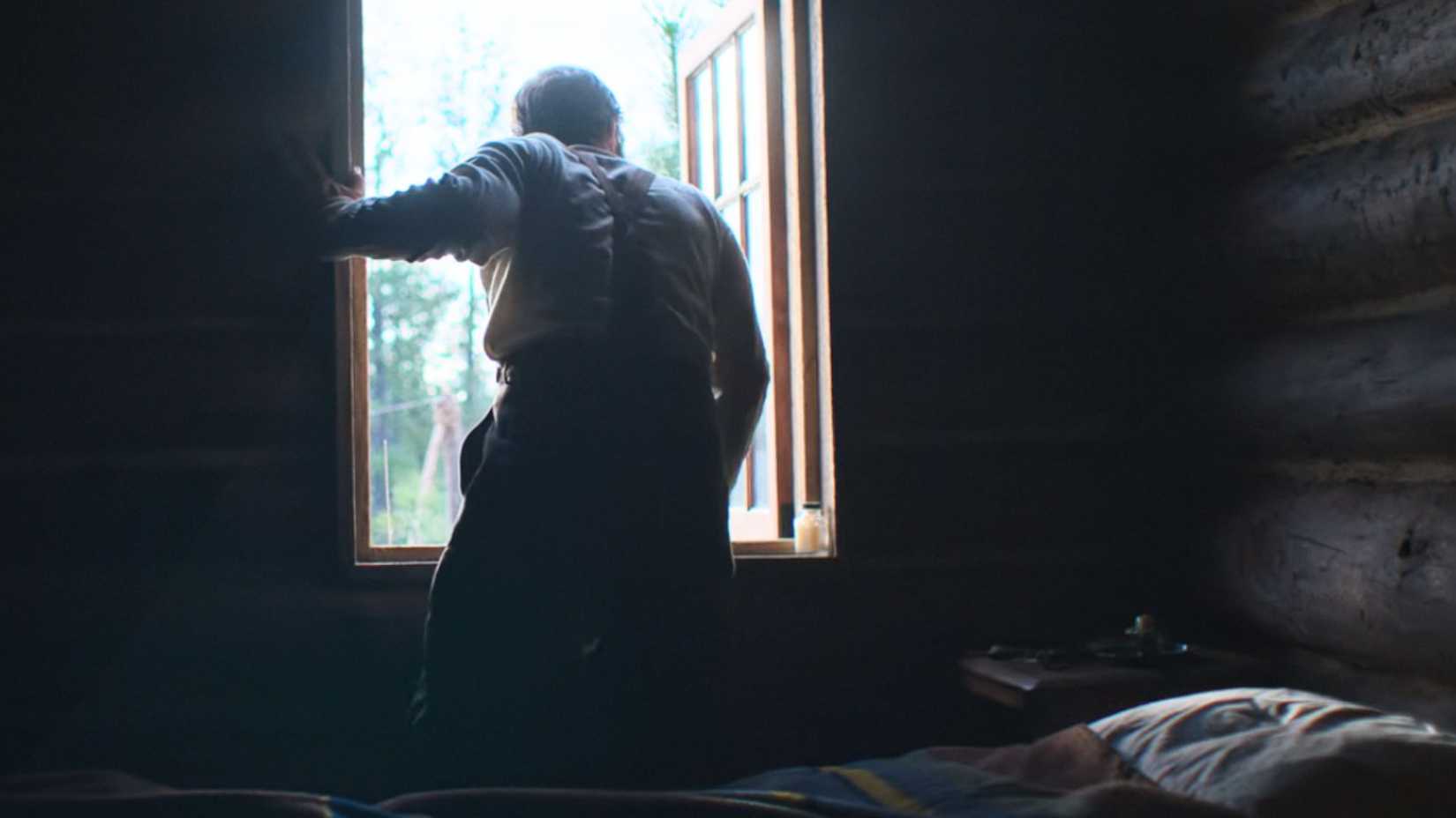 Joel Edgerton looking out a window as Robert Grainer in Train Dreams