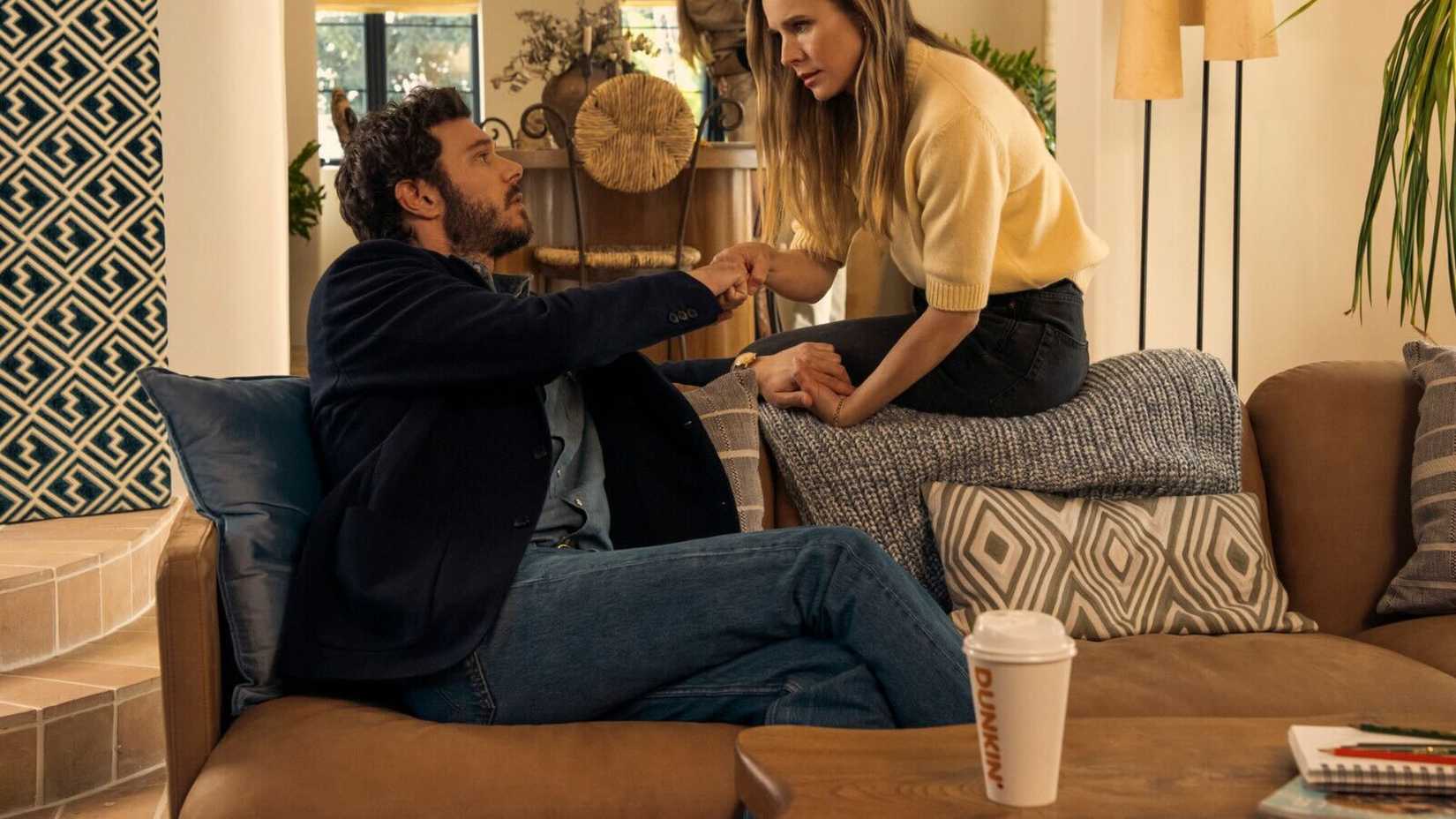 Kristen Bell and Adam Brody in Nobody Wants This with a Dunkin Donuts cup on the table