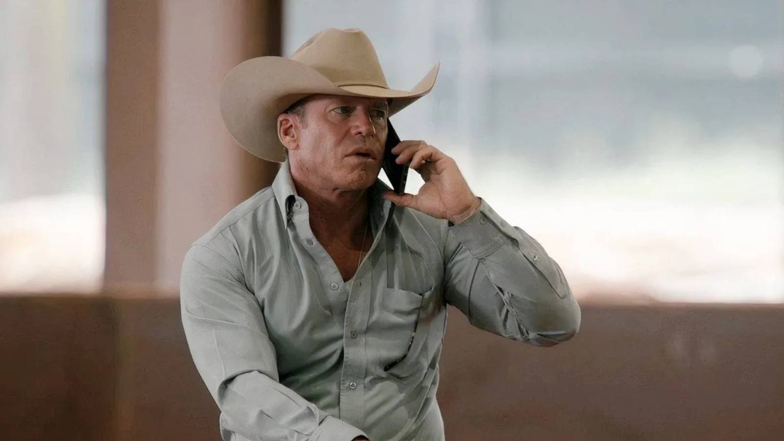 Taylor Sheridan in Yellowstone talking on his phone while riding a horse
