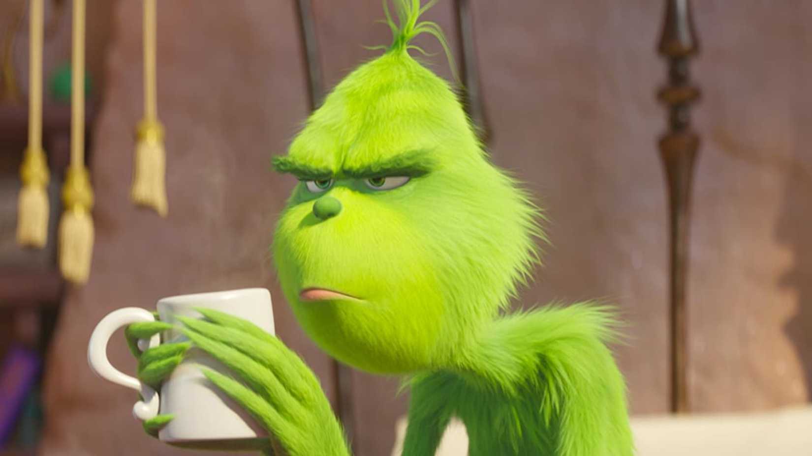 The Grinch holds a coffee mug in The Grinch