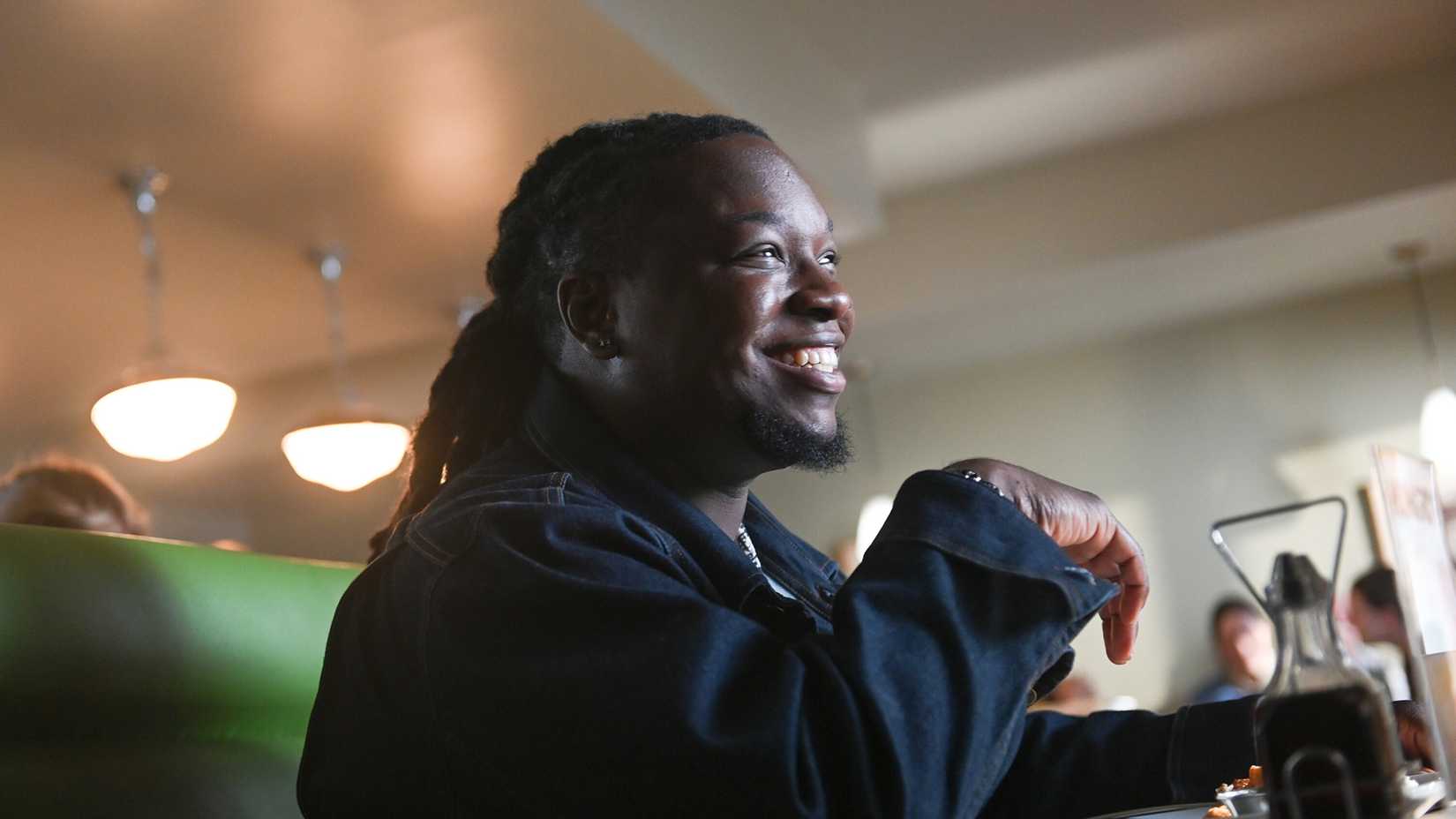 Randy sitting in a diner smiling in Tracker.