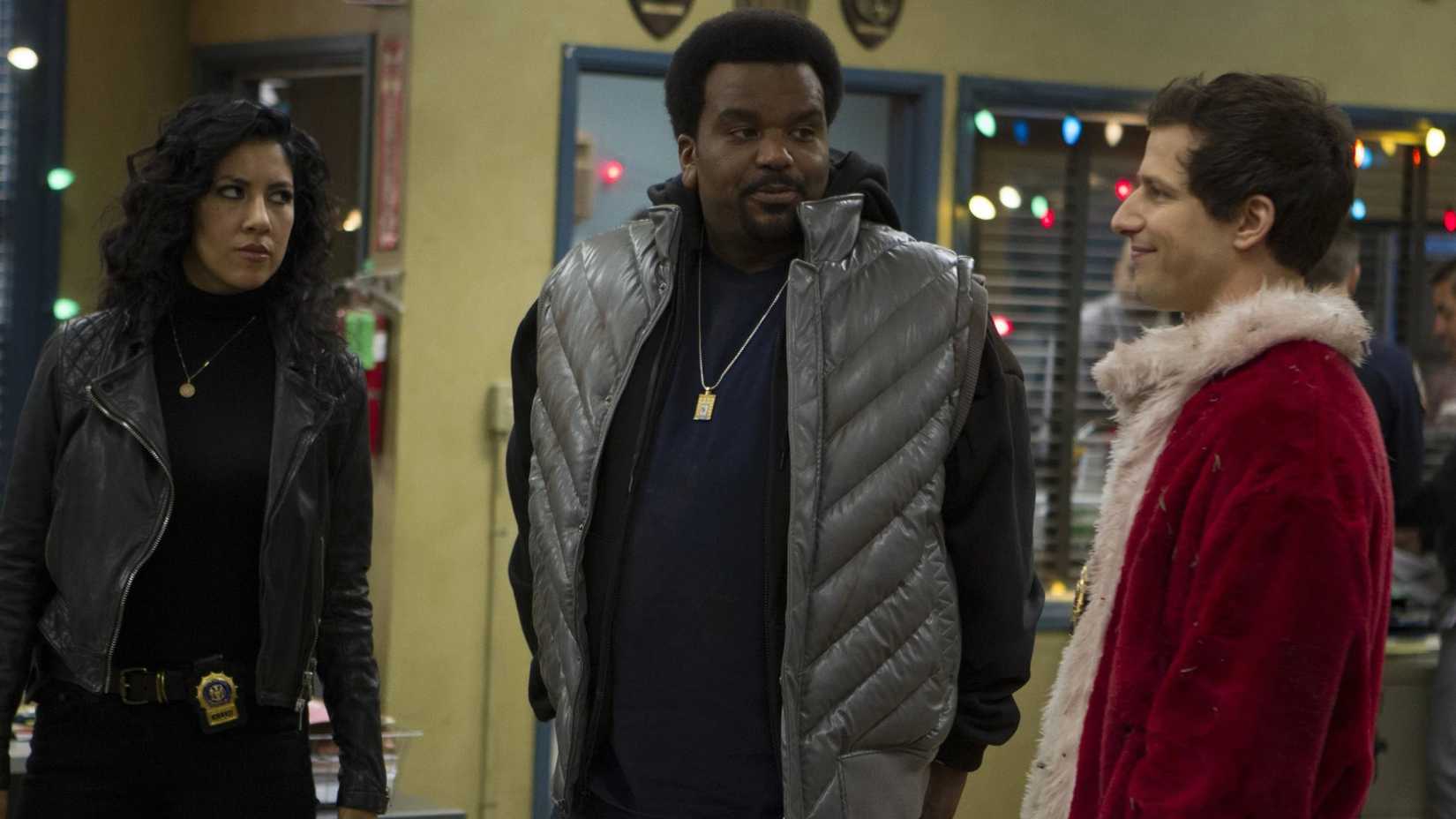 Doug Judy, Rosa, and Jake standing around together in the precint, talking about Giggle Pig, in Brooklyn Nine-Nine.