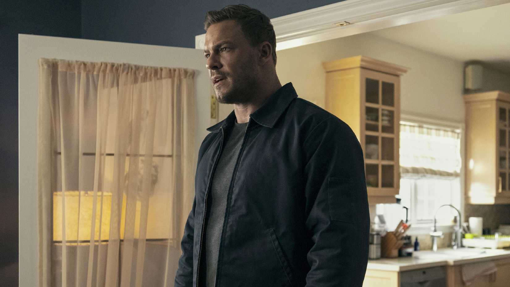 Alan Ritchson staring at something in Reacher