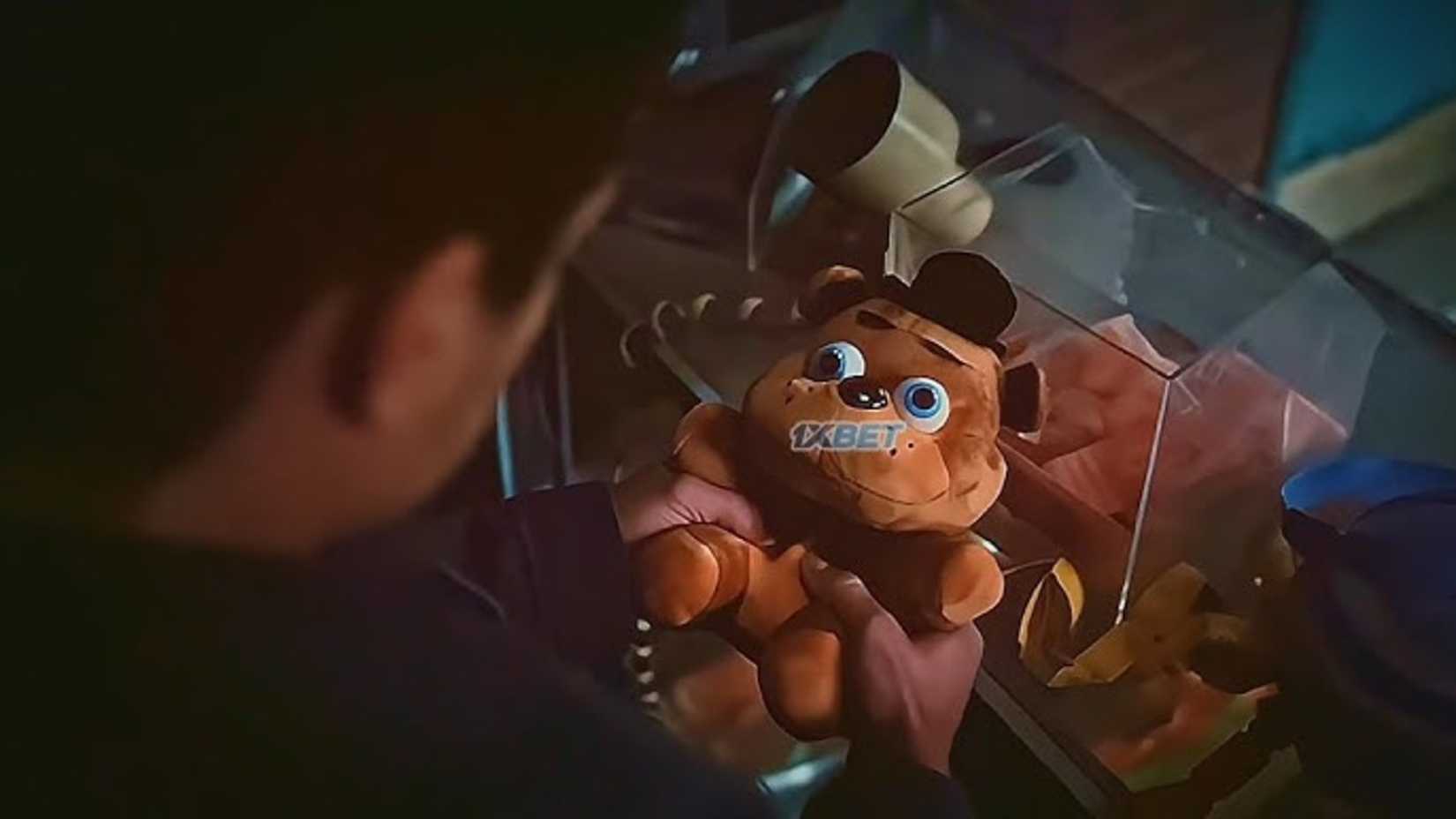 A FredBear Plush toy is held in Five Nights at Freddy's 2